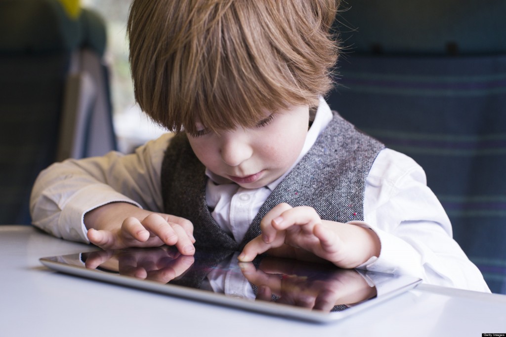Young boy travels with tablet on train