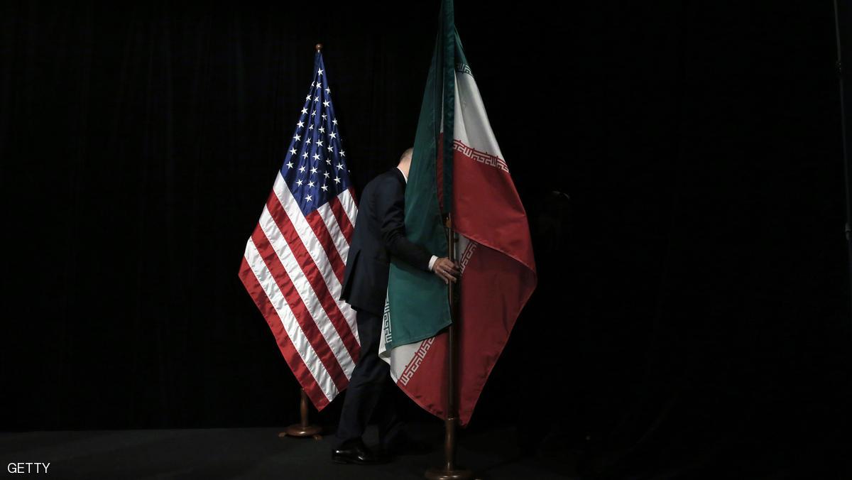 A staff removes the Iranian flag from the stage after a group picture with foreign ministers and representatives of Unites States, Iran, China, Russia, Britain, Germany, France and the European Union during the Iran nuclear talks at Austria International Centre in Vienna, Austria on July 14, 2015. Major powers clinched a historic deal aimed at ensuring Iran does not obtain the nuclear bomb, opening up Tehran's stricken economy and potentially ending decades of bad blood with the West.   AFP PHOTO / POOL / CARLOS BARRIA / AFP / POOL / CARLOS BARRIA        (Photo credit should read CARLOS BARRIA/AFP/Getty Images)