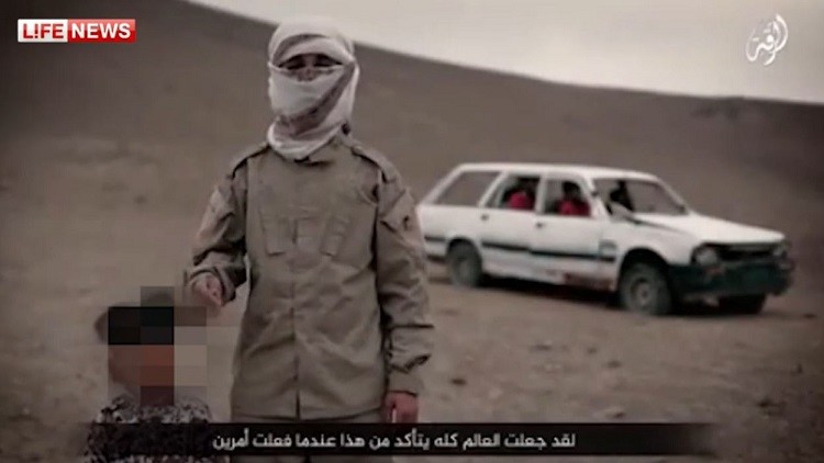 احد مسلحي "داعش" برفقة "الطفل السفاح" تم إخفاء وجهه